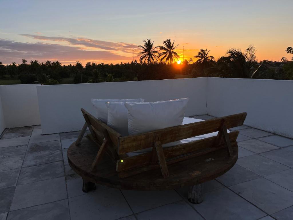 a wheelbarrow with pillows on a balcony with the sunset at Vila Bless 4 bedroom Vila with pool, garden and beach tennis court in Prea