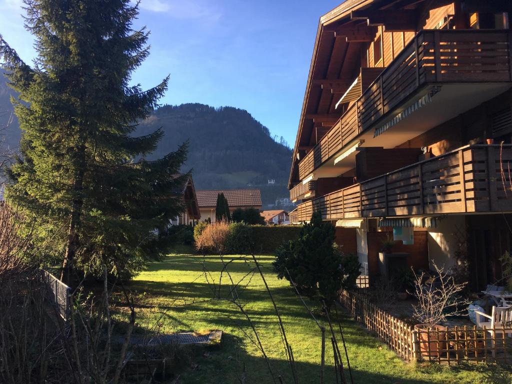 a building with a tree and a church in the background at Ferienwohnung Interlaken/Wilderswil in Wilderswil