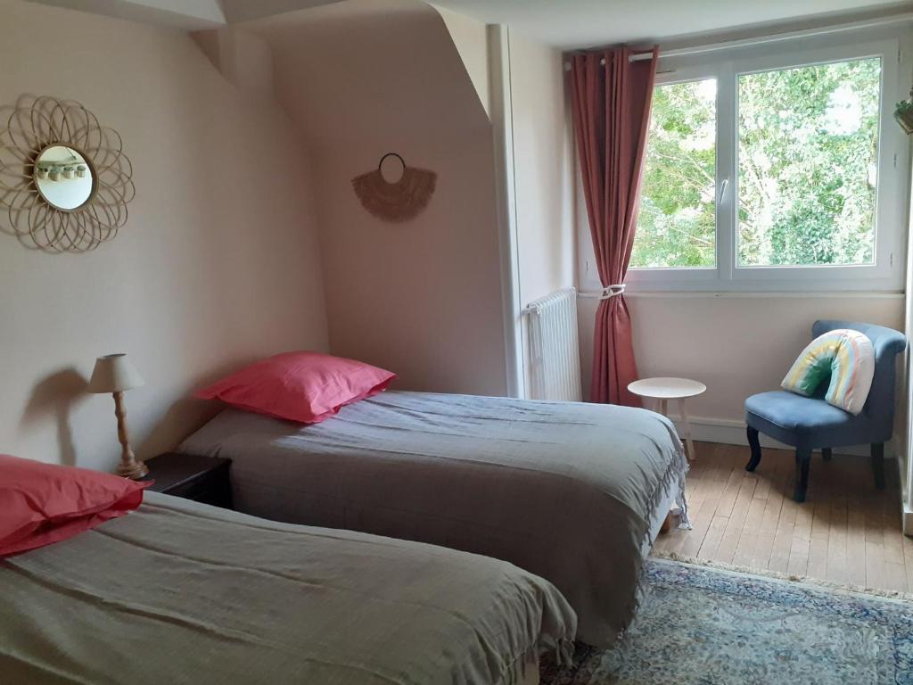 - une chambre avec deux lits, une fenêtre et une chaise dans l'établissement Le Peu'ty Cottage, à Fougères-sur-Bièvre