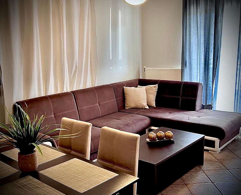 a living room with a brown couch and a table at CW Flat in Alexandroupoli