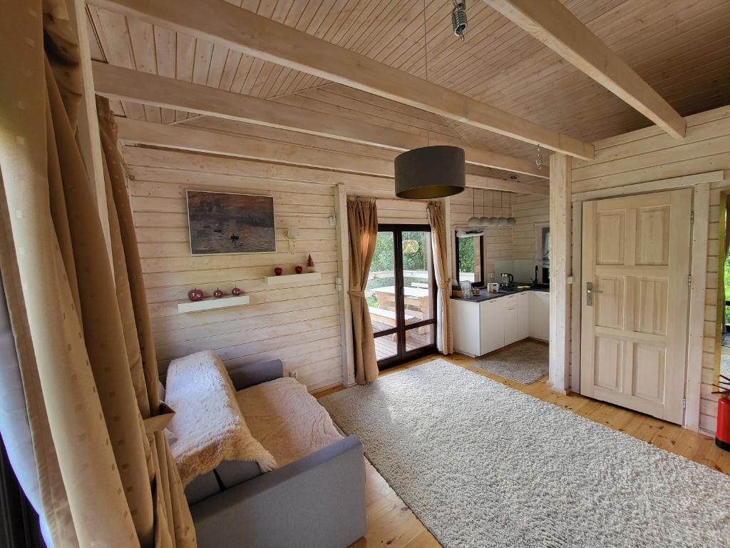 ein Wohnzimmer mit Sofa und Tür in der Unterkunft Domek 105 in Gietrzwałd