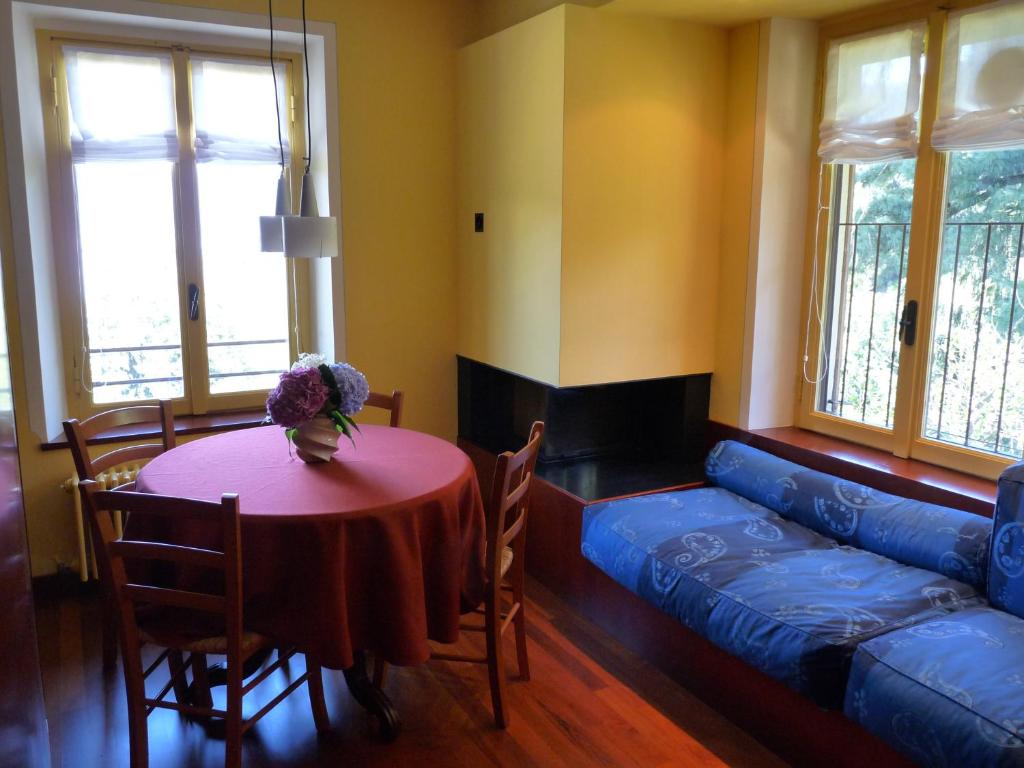 ein Wohnzimmer mit einem Tisch und einem blauen Sofa in der Unterkunft Apartment Lido in Gozzano