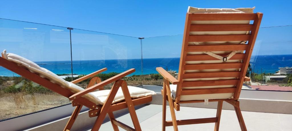 a wooden chair sitting in front of a window at Romantica Apartments in Falasarna