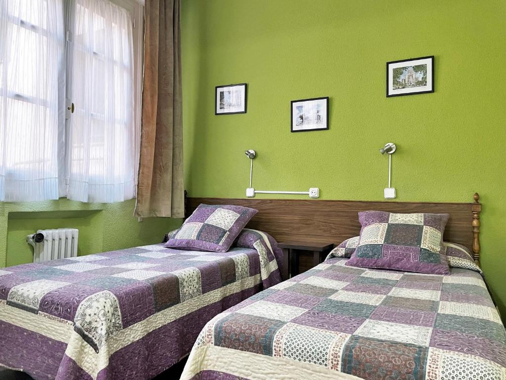 A bed or beds in a room at Hostal San Martin