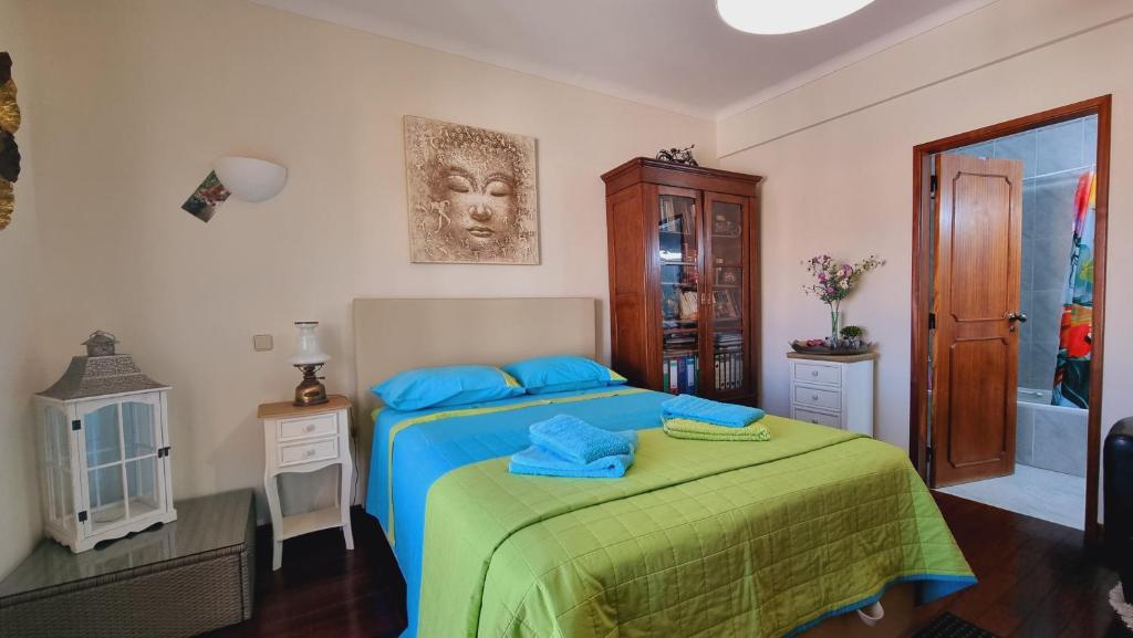 um quarto com uma cama com almofadas azuis em Quarto en-suite Casa Cristina em Lagos