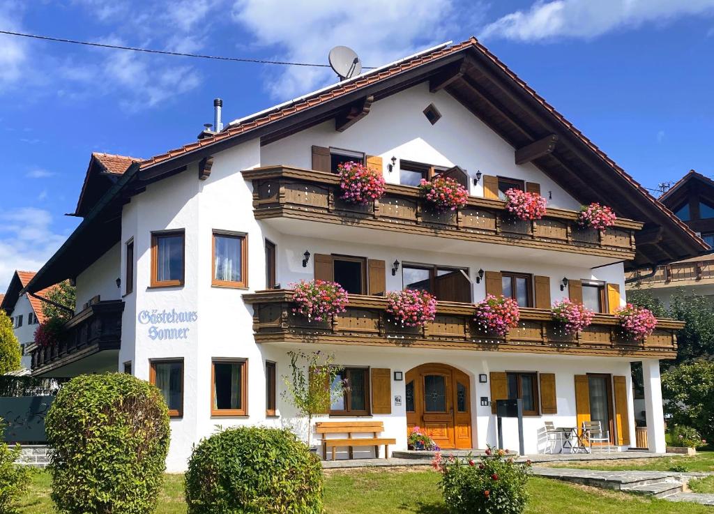 a white building with flowers on the balcony at Gästehaus Sonner in Dietmannsried