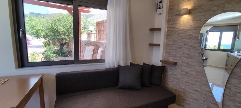 a living room with a couch and a large window at Romantica Apartments in Falasarna
