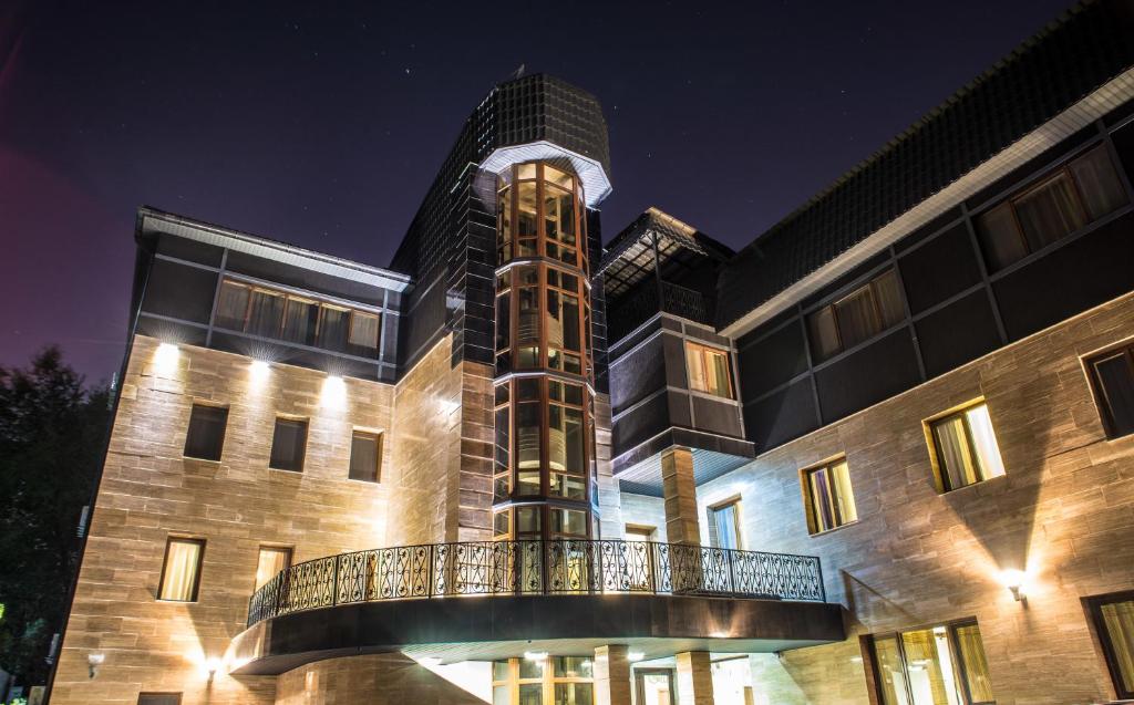 a building with a tower on top of it at night at Grushevy Hospitality Boutique in Almaty