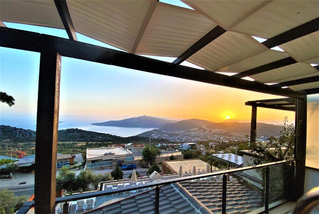 einen Blick auf den Sonnenuntergang vom Balkon eines Hauses in der Unterkunft Sultan Hotel Kalkan in Kalkan