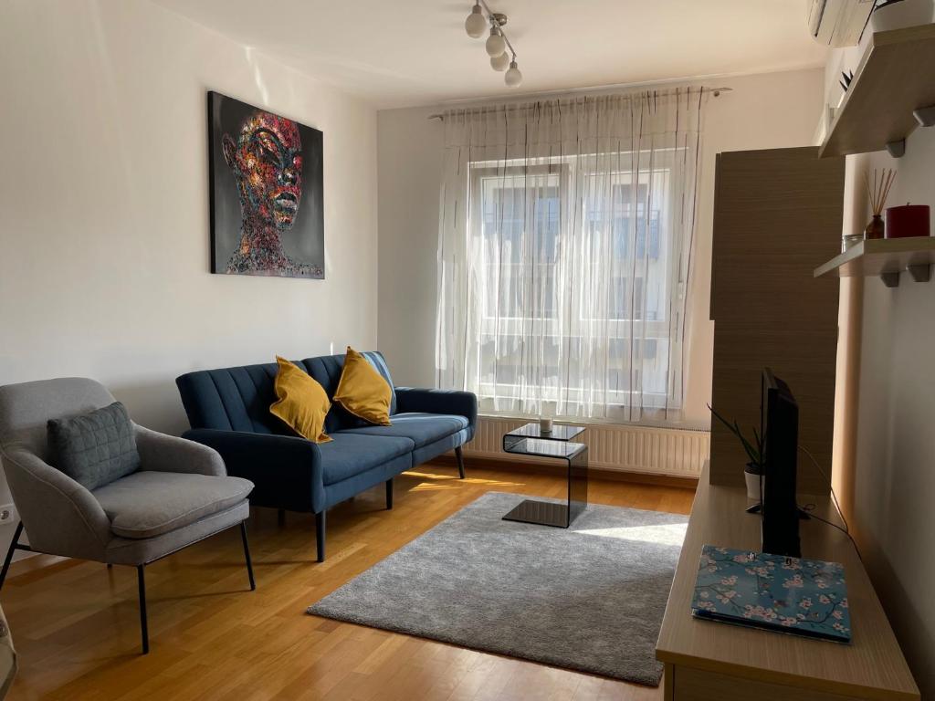 een woonkamer met een blauwe bank en een stoel bij Apartment Jelena in Zagreb