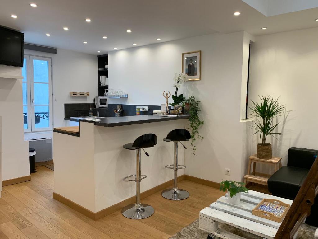 une cuisine avec un comptoir et des tabourets dans une pièce dans l'établissement Lovely studio at Île Saint-Louis, à Paris