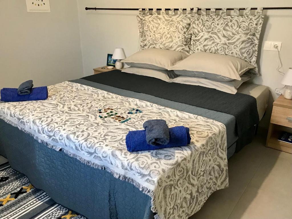 - une chambre avec un lit et des serviettes bleues dans l'établissement The Mill House Stella, à Symi