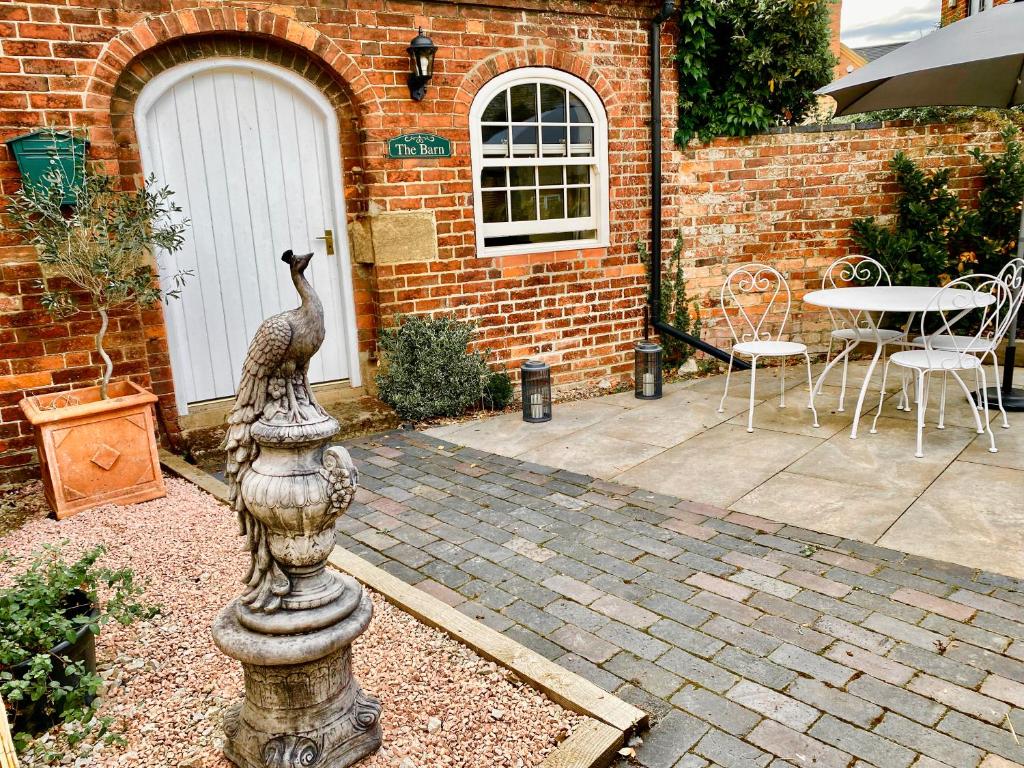 a statue of a peacock on a fountain in a garden at The Barn at Meadow Farm in Derby