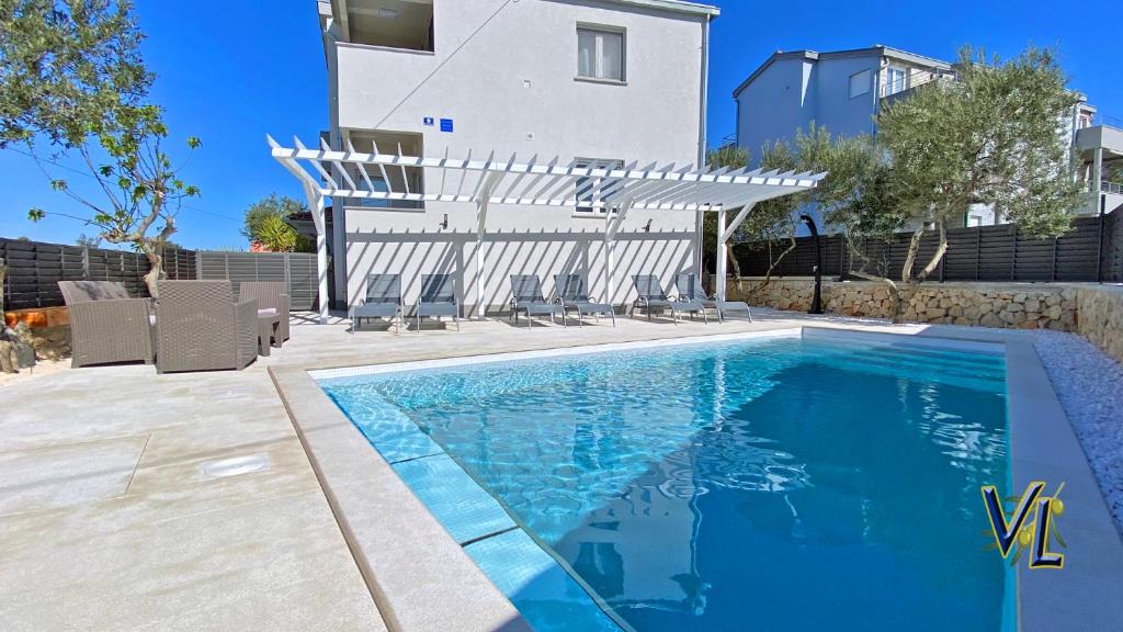 una piscina di fronte a una casa di Pakostane - VRGADA -appartement 50 m2 avec piscine a Pakoštane