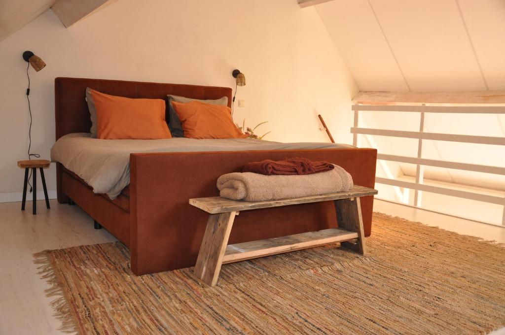 a bedroom with a large bed with a wooden frame at B&B Sonnehuys in Nieuwland
