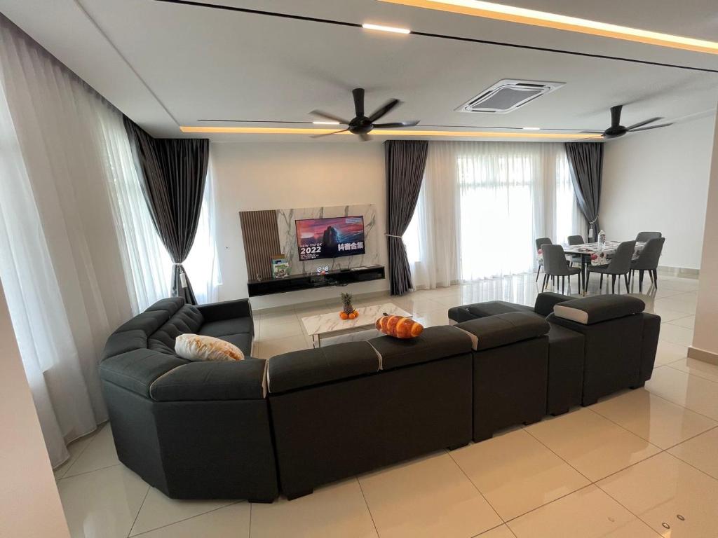 uma sala de estar com um sofá preto e uma mesa em 福氣安康 Ray’s Homestay em Batu Pahat