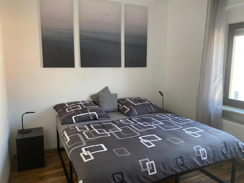 a bedroom with a bed and two pictures on the wall at Apartment Katharina in Püttlingen