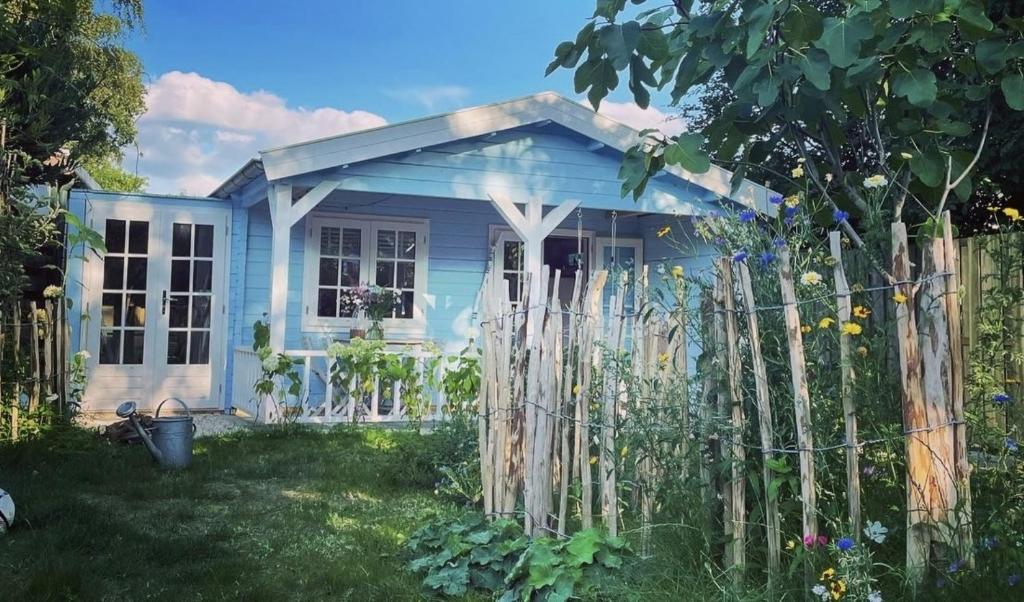 een klein blauw huis met een hek in de tuin bij Bed and breakfast de Heg in Geldrop