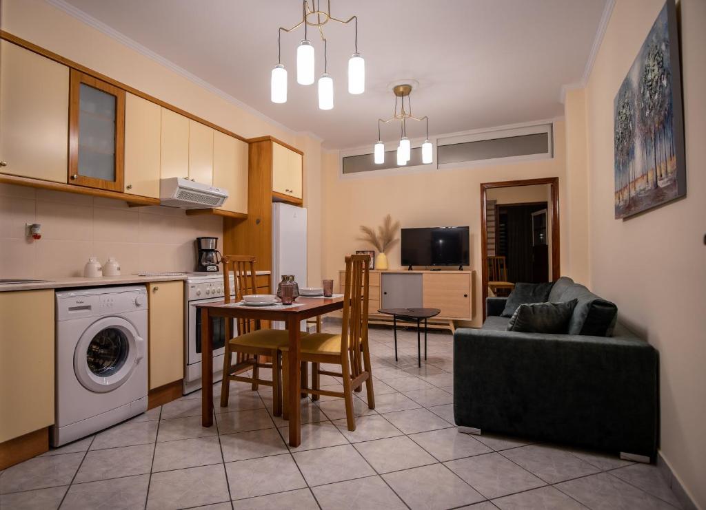 a kitchen and living room with a table and a couch at Ariadni Luxury Apartment in Samos