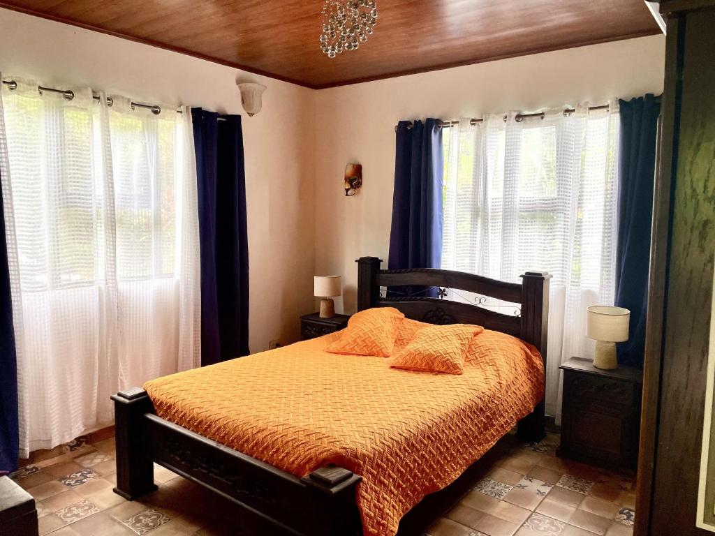UjarrásにあるEl Ensueñoのベッドルーム1室(オレンジのシーツと窓付きのベッド1台付)