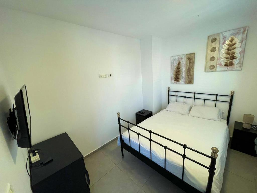 a bedroom with a bed and a flat screen tv at GK apartment Harmony in Bat Yam