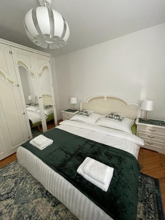 a bedroom with a large bed with two towels on it at Green Apartment in Koło