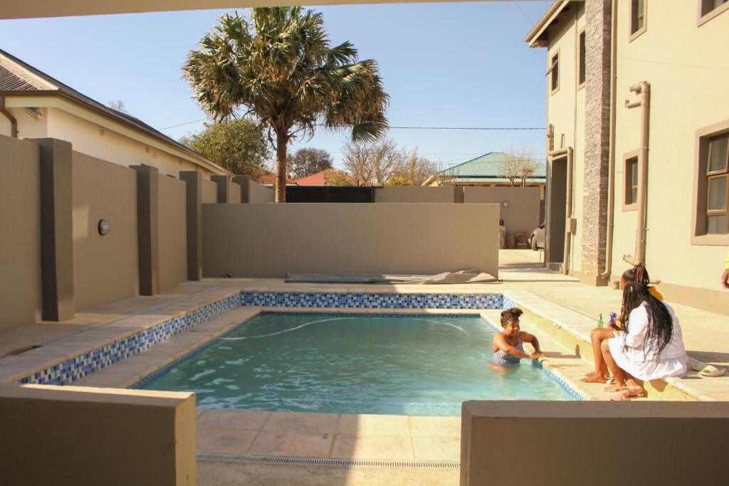 deux filles jouant dans une piscine dans une maison dans l'établissement Alu Boutique Hotel and Conference, à Roodepoort