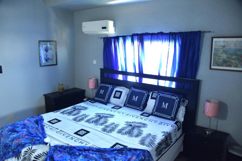 a bedroom with a large bed with a blue curtain at Royal Exquisite Deluxe B&B in Kingston