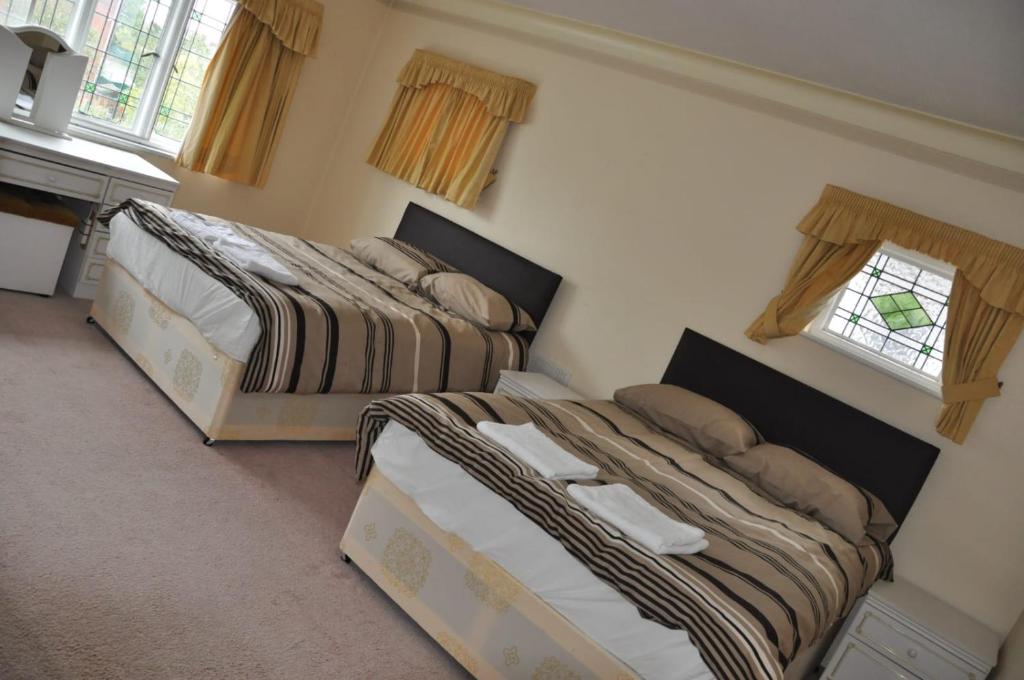 two beds sitting next to each other in a bedroom at Ridgeways house in Wanstead