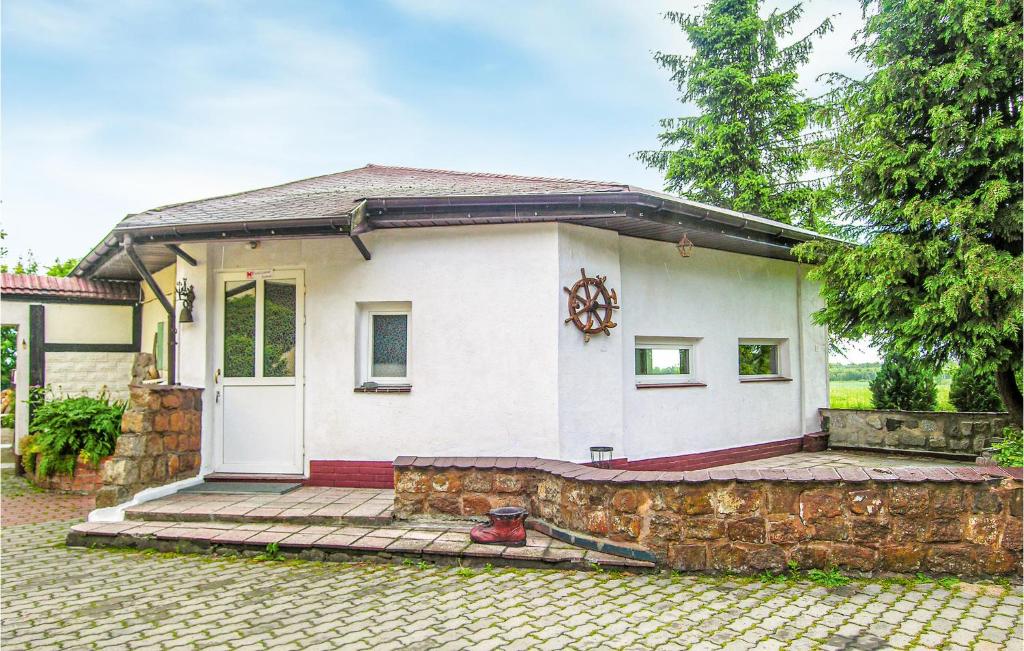 una pequeña casa blanca con una pared de piedra en Pet Friendly Home In Maszewo With Wifi, en Maszewo