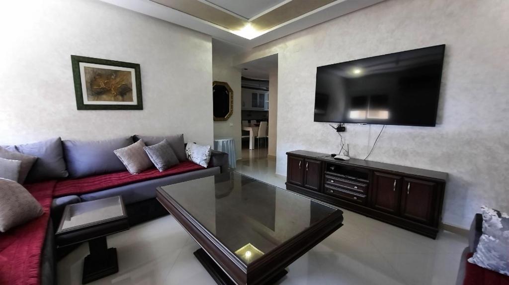 a living room with a couch and a flat screen tv at شقة الكرنيش in Nador