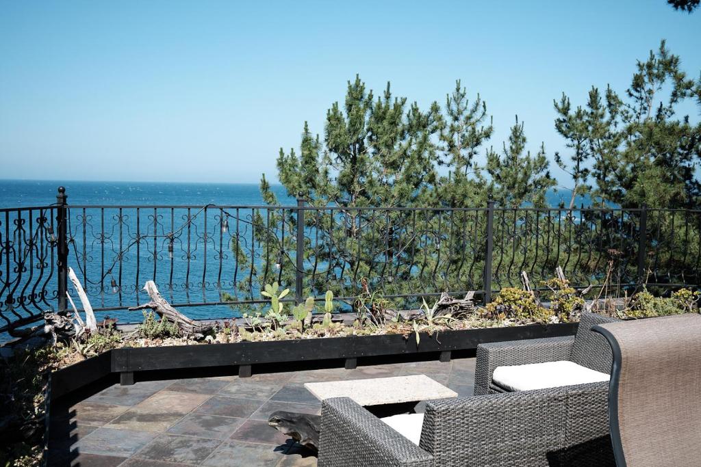 un patio con 2 sillas y vistas al océano en ISANA Resort, en Ito