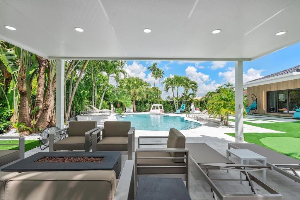 een achtertuin met een zwembad en een witte parasol bij VillaLee-Jungle Palm Island white marble pool Area in Miami