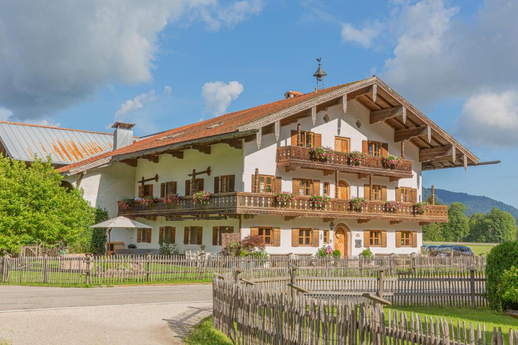 uma casa grande com uma cerca em frente em Knoglerhof em Ruhpolding