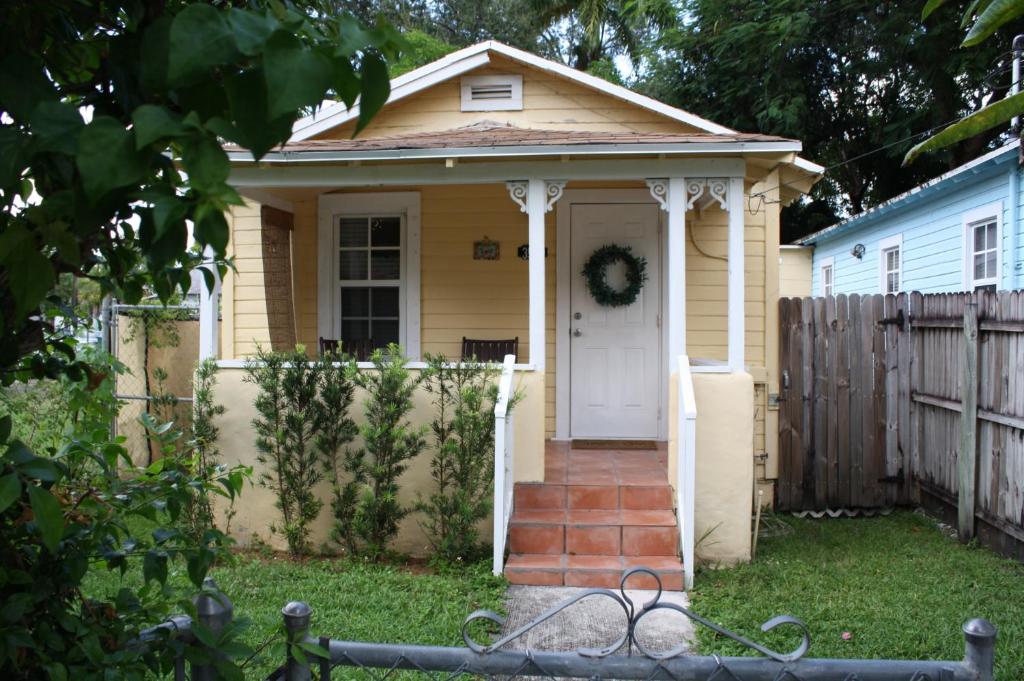 uma pequena casa amarela com uma porta branca em Key West Style Historic Home in Coconut Grove Florida The Yellow House em Miami