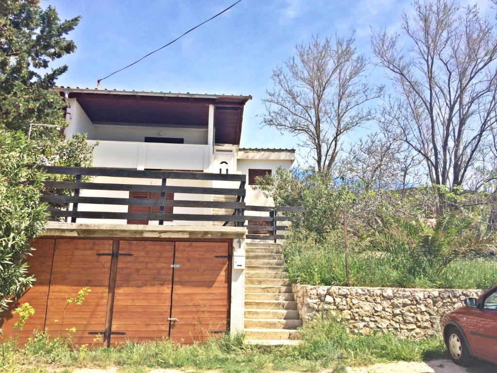 a house with stairs leading up to a garage at Apartments and rooms by the sea Stara Novalja, Pag - 11626 in Novalja