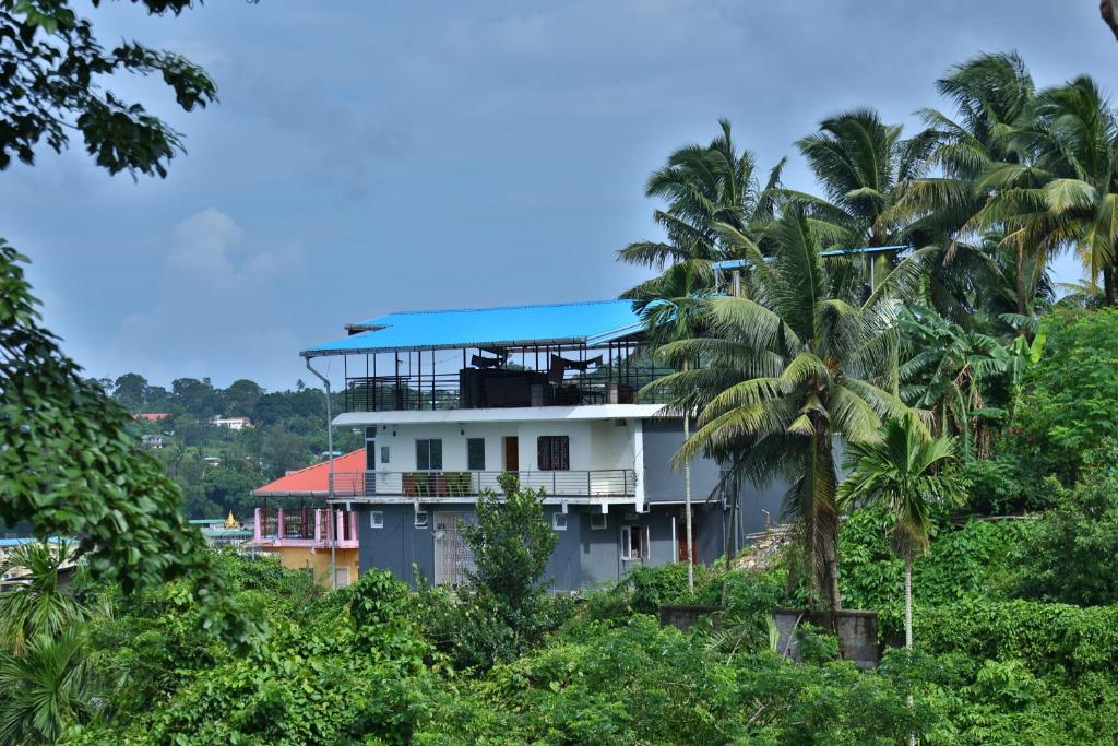a building on a hill with palm trees at The Lagoon shade in Port Blair