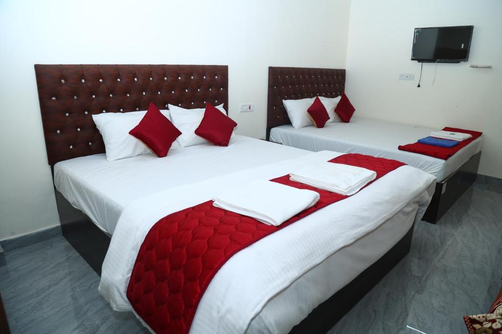 two beds in a hotel room with red pillows at The Lagoon shade in Port Blair