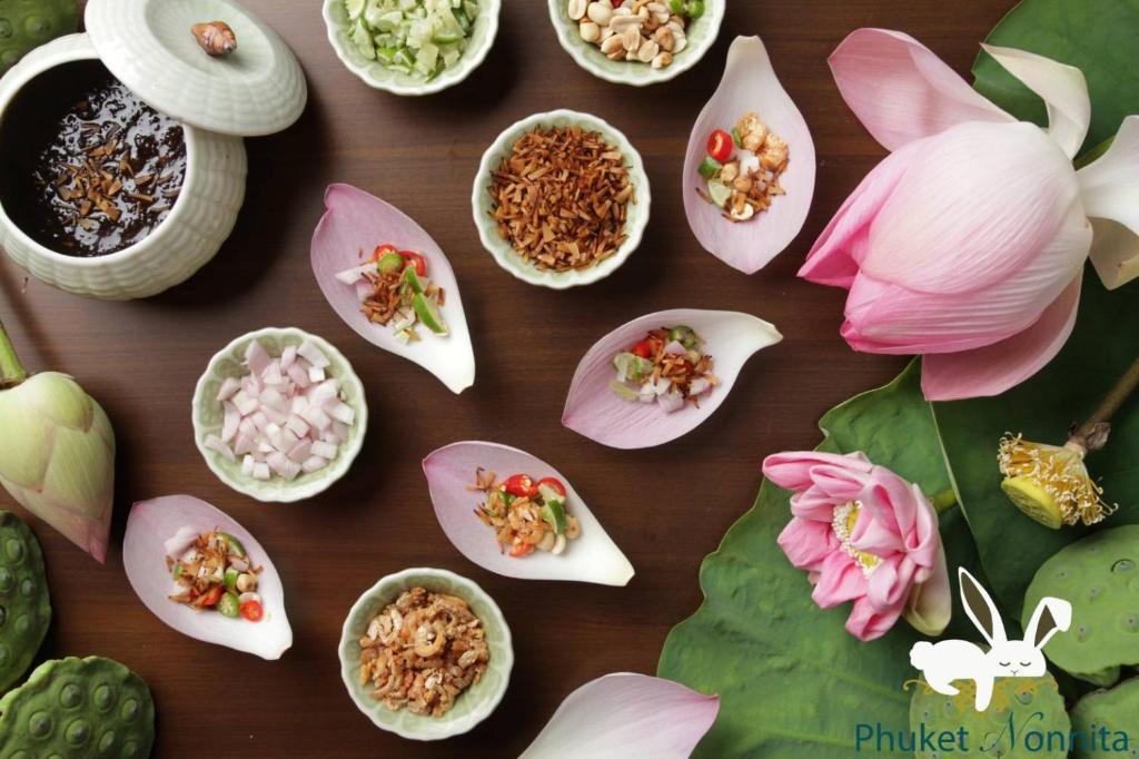 a table with many different types of food in flowers at Phuket Nonnita Boutique Resort - SHA Plus in Phuket