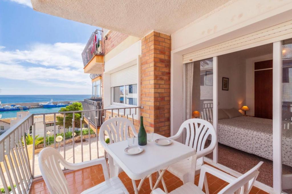 Habitación con balcón con mesa y sillas. en Ametlla Gem by the Harbour en L'Ametlla de Mar