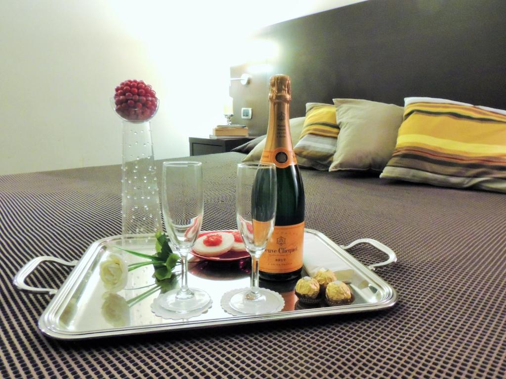 Florida rooms - comfort Hotel في روما: صينية مع زجاجة من الشمبانيا واكواب على السرير