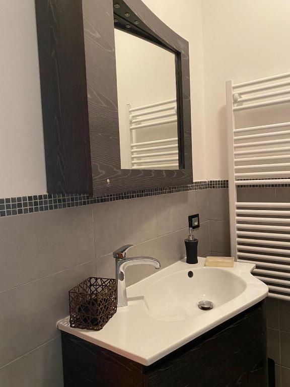 łazienka z białą umywalką i lustrem w obiekcie Chirone Room w mieście Mondello