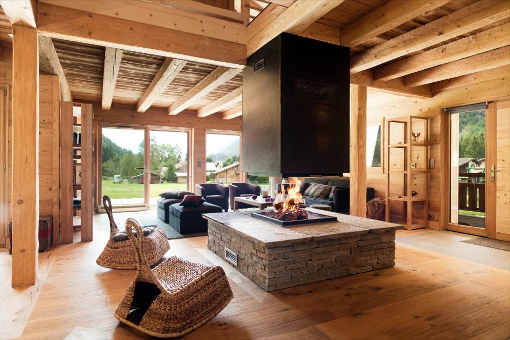 ein Wohnzimmer mit einem Kamin in einer Blockhütte in der Unterkunft Hevea in Chamonix-Mont-Blanc