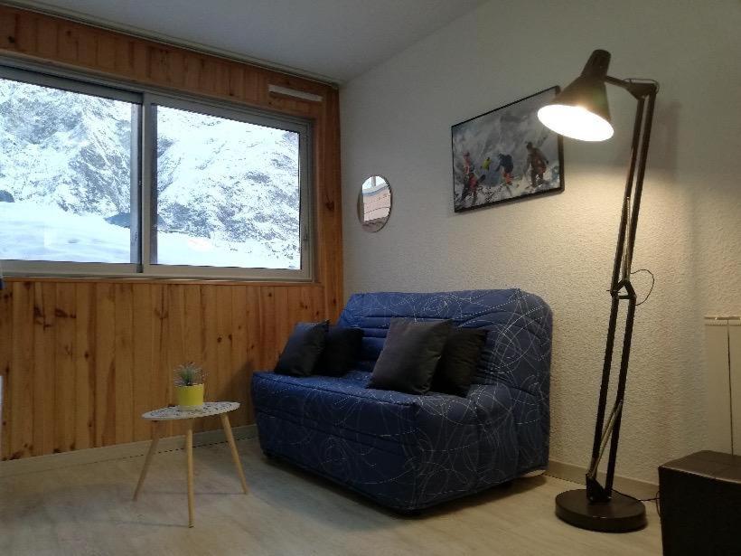 uma sala de estar com um sofá azul e um candeeiro em Ski Piau engaly 50 m des pistes de ski et du cœur de station em Aragnouet