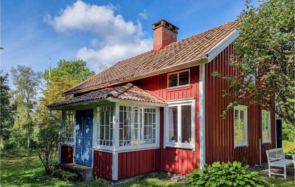 una casa roja con una puerta blanca y ventanas en Amazing Home In Frgelanda With Kitchen, en Färgelanda