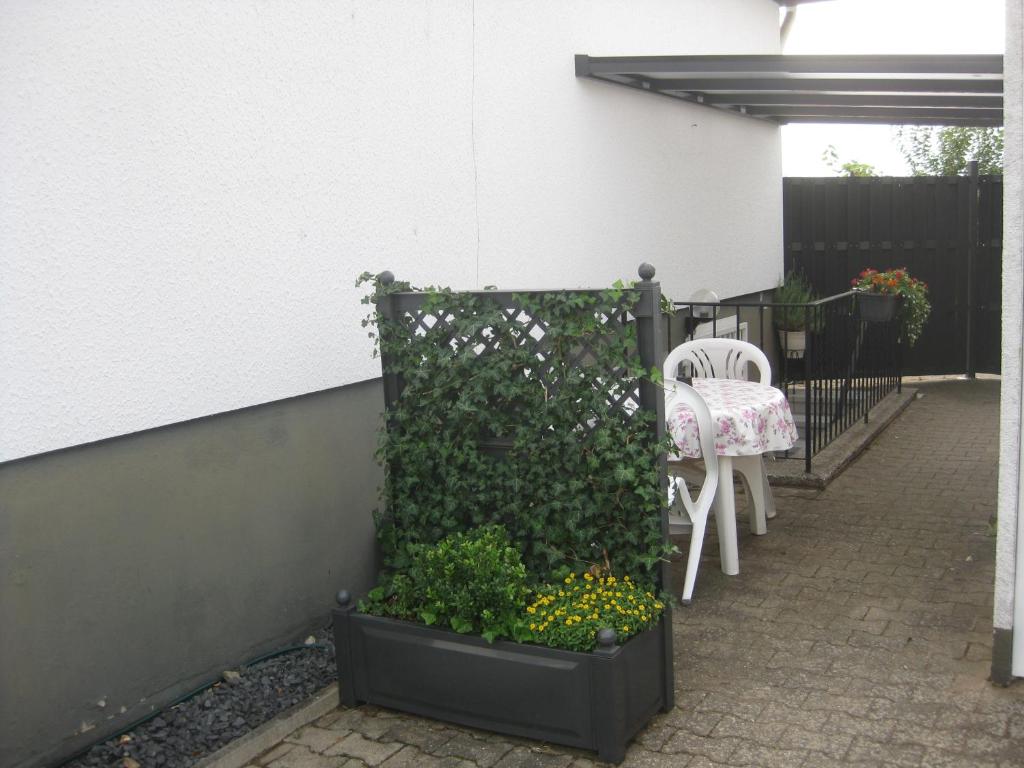 a patio with a table and a chair and some plants at Main-Kinzig Gästewohnung in Hasselroth