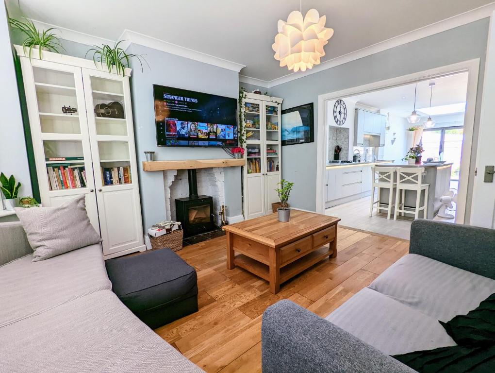 a living room with a couch and a fireplace at Beautiful 4 Bed Portsmouth Home Bright & Modern with Garden & Free Parking & Spa Bath & Fully Equiped Kitchen Perfect For Work or The Family in Portsmouth