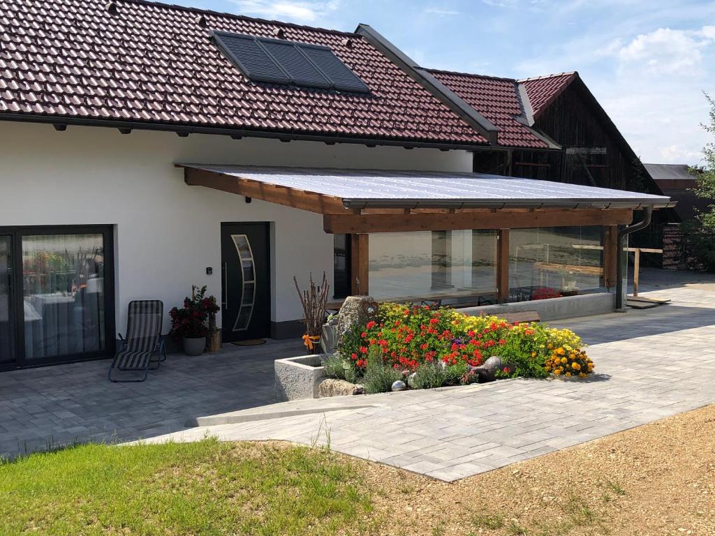 a house with a solar roof and a garden with flowers at Landhof Böhm in Arbesbach