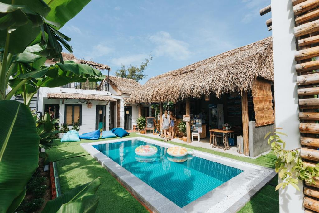 a villa with a swimming pool in front of a house at Wanderlust in An Bang
