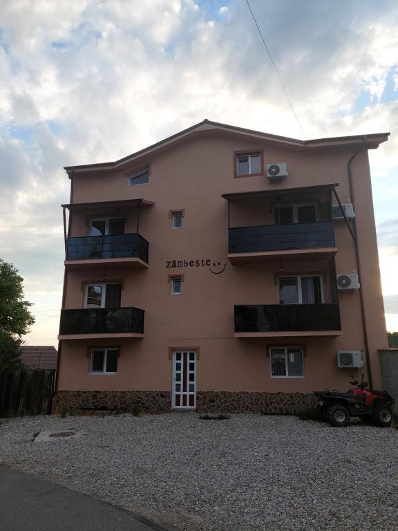 un edificio rosa con balcones en un lateral en Varipatti House en Slatina